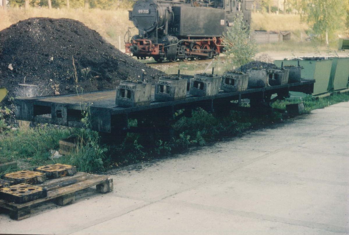 Ohne Seitenwände, ohne Zugeinrichtung, mit einem Blech abgedeckt – so übernahm die Preßnitztalbahn im Juni 1993 das Untergestell. 97-19-25 am 10. Oktober 1992 am Rand in Wilsdruff vor 99 715.