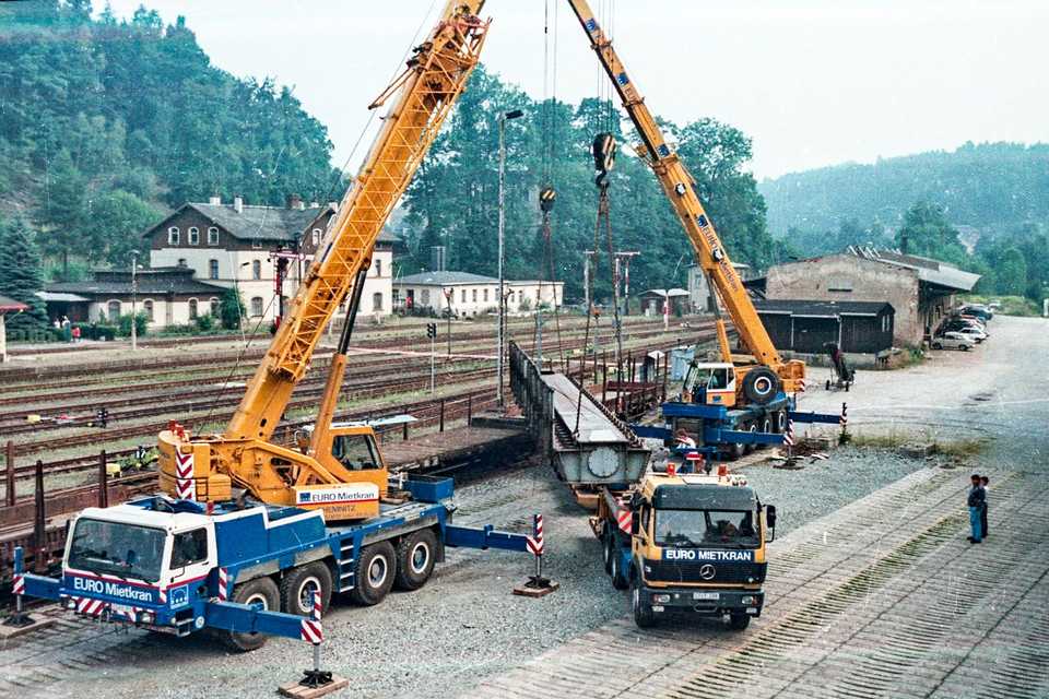 Der künftige Überbau der Brücke Km 18,7 über die Preßnitz zwischen Schmalzgrube und Forellenhof kommt in Annaberg-B. unterer Bahnhof auf Eisenbahnfahrzeugen an und wird per Straßentieflader nach Schmalzgrube gebracht.
