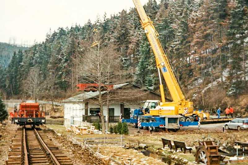 Das Gleis zwischen Bahnübergang Kilometer 18,7 und Forellenhof ist montiert, jetzt werden Schotterwagen und Diesellok „angeliefert“, damit das Einschottern erfolgen kann, solange die Verbindung bis zum Bahnhof Schmalzgrube noch nicht hergestellt ist.