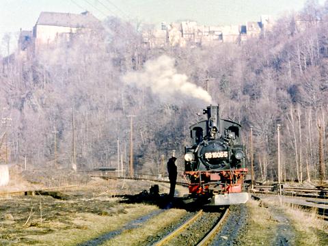 Vor der Kulisse des Wolkenstein Schlosses steht 99 1606-5 am 10. März 1986 im Güterteil des Bahnhofs Wolkenstein.