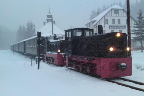 Mit der Kraft der zwei Dieselloks 199 007-6 und 199 009-2 wird ein Sonderzug mit sechs Wagen durch das dichte Schneetreiben in Richtung Jöhstadt gezogen.