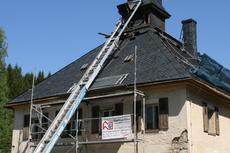 An der ehemaligen Fabrikantenvilla am Bahnhof Schlössel wird ein Gerüst aufgestellt, um Arbeiten am Dach und den Wiedereinbau der rekonstruierten Turmuhr ausführen zu können.