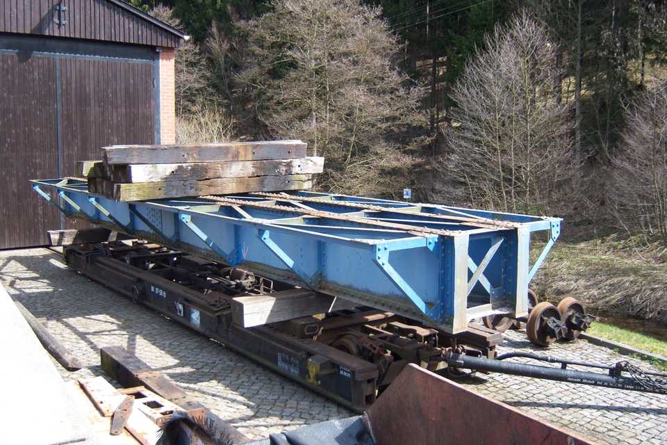 Der alte Brückenüberbau ist auf einem Rollfahrzeug vor der Fahrzeughalle in Schmalzgrube abgestellt.