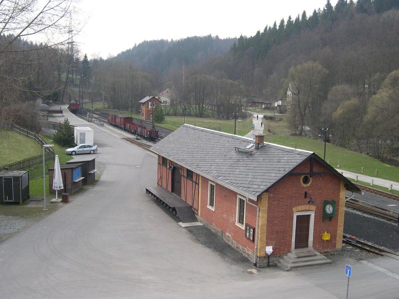 Blick vom ehemaligen Eisenbahnerbeamtenwohnhaus auf das Bahnhofsgebäude in Steinbach. Im hinteren Teil (mit seitlicher Laderampe) befindet sich die Güterabfertigung, im vorderen Teil des Gebäudes ein Warteraum für Fahrgäste und ein Dienstabteil.