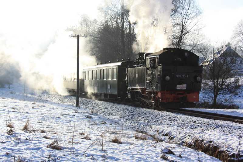 Zug mit VI K 99 1715-4 bei morgendlicher Sonne und Schnee kurz vor dem Bahnhof Schlössel.