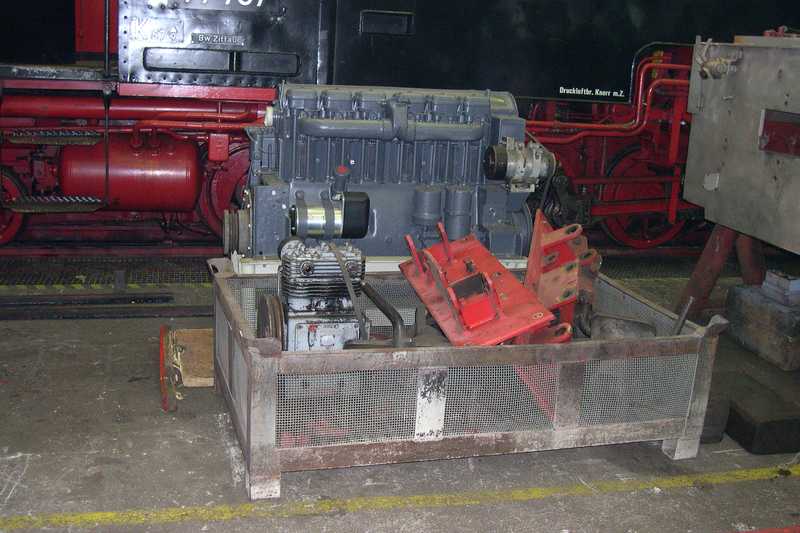 Der Motor und weitere Teile stehen einzeln demontiert.