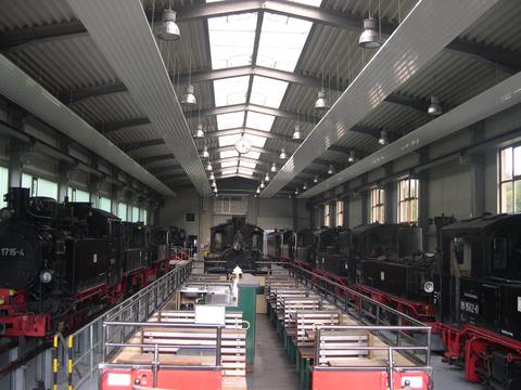 Ein Aussichtswagen und viele Dampfloks in der Ausstellungs- und Fahrzeughalle.