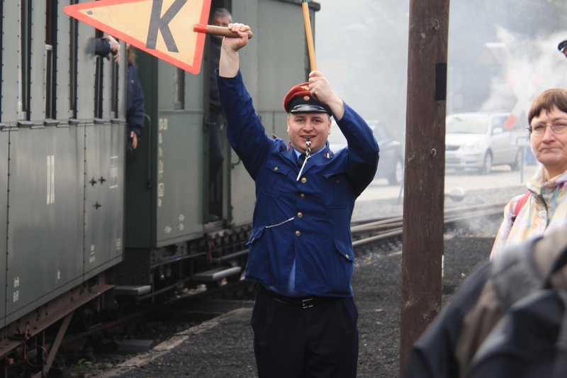Der Zugleiter in Schmalzgrube signalisiert dem Triebfahrzeugpersonal, dass die Fahrzeit zu kürzen ist.