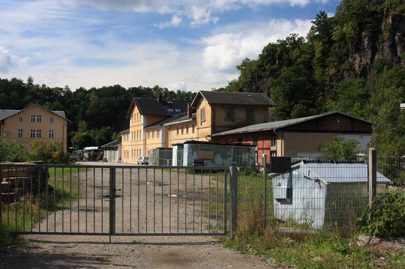 Blick von der Ladestraße in Richtung Bahnhofsgebäude (links) sowie Lokschuppen und ehemaliger Bahnverwalterei (rechts).