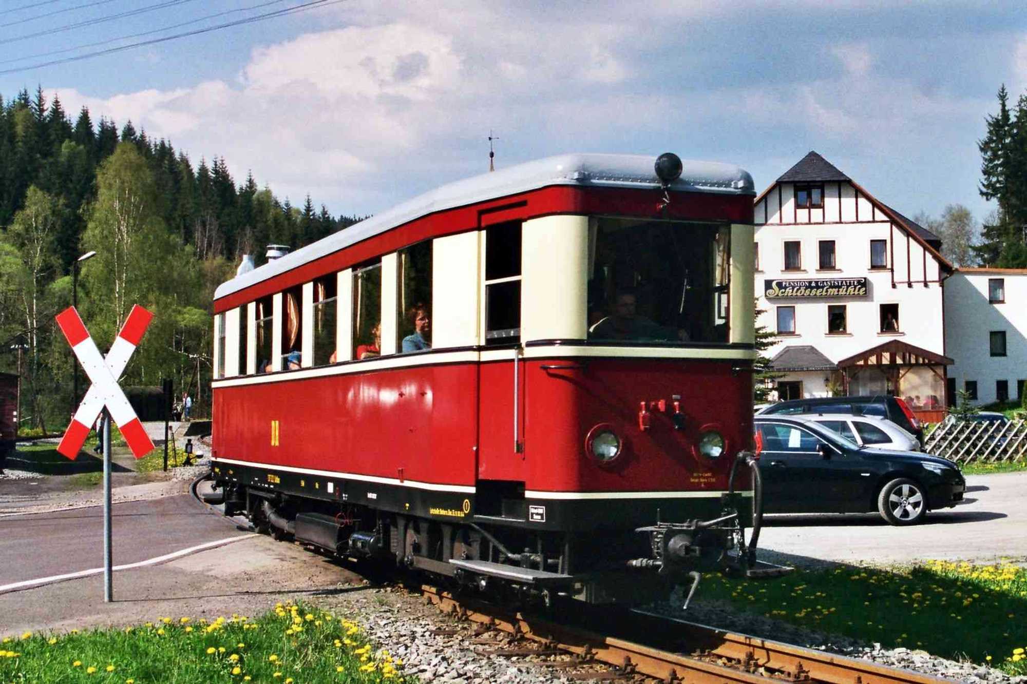 Der Triebwagen aus Zittau quert den Bahnübergang in Schlössel.