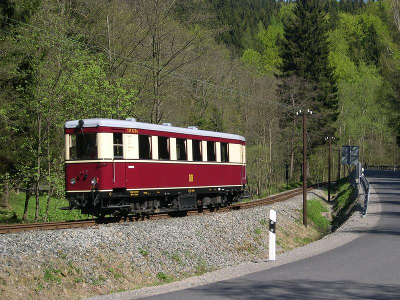 Der Triebwagen nähert sich dem Bahnübergang der Straße nach Grumbach.