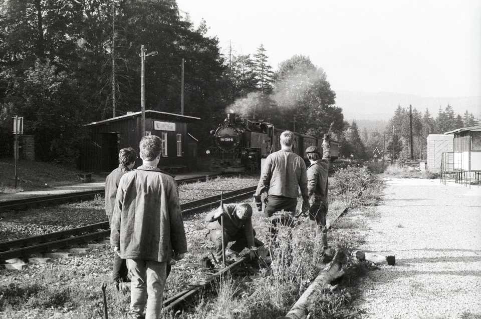 Während Mitglieder der IG Preßnitztalbahn in Kretzscham-Rothensehma die Weiche von Gleis 3 demontieren, nähert sich 99 1781-6 mit einem Zug in Richtung Oberwiesenthal.