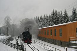 Ein Zug mit der VI K 99 1715 passiert die Lagerhalle in Schlössel.