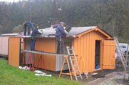 Der alte Dachpappenbelag auf der Holzhütte wird durch neue Dachpappe ersetzt.