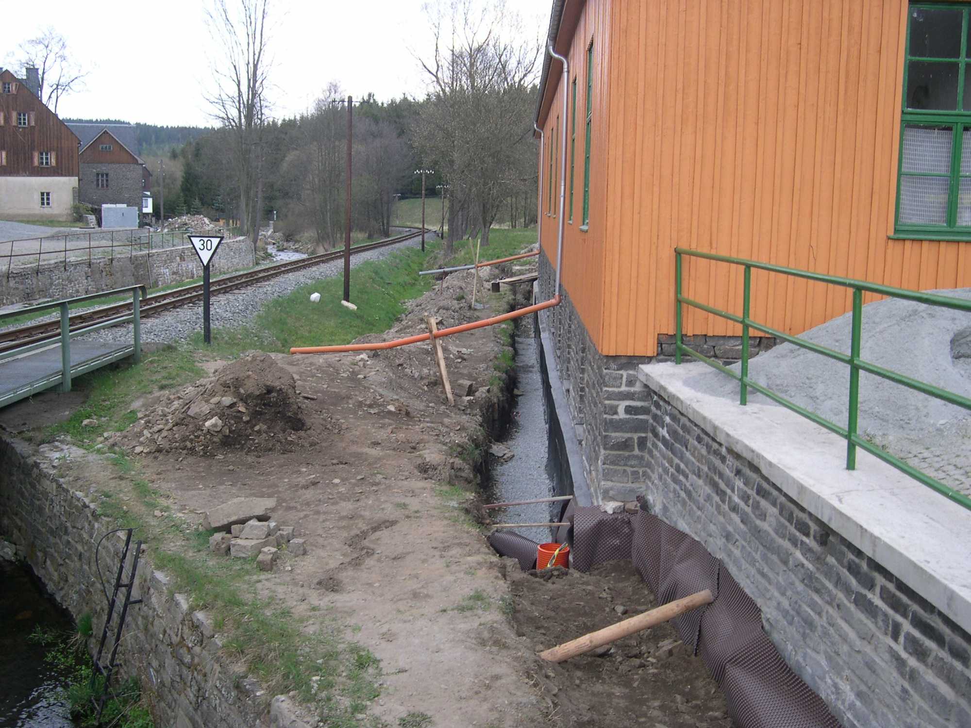 Der vorgefüllte Beton am Fundament auf der Gleisseite wird mit Folie geschützt.