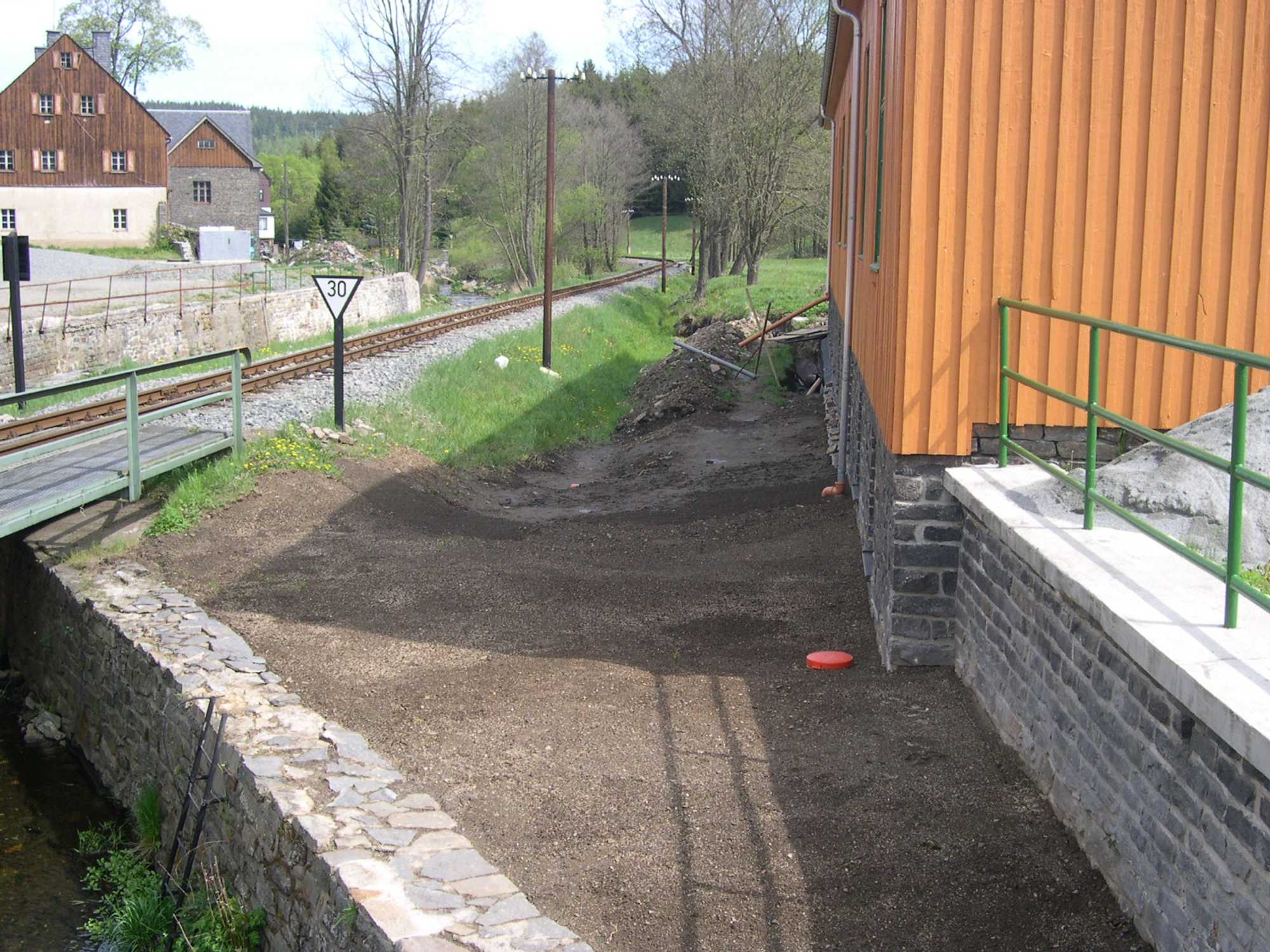 Der Abschnitt der Fundamentsanierung an der Brücke ist schon wieder verfüllt und Gras angesät.