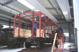 In den neu aufgebauten Stahlträgerrahmen werden die ersten Beplankungsbretter eingebaut.