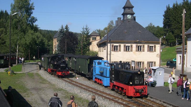 Im Bahnhof Schlössel passiert hier der Personentzug von Steinbach nach Jöhstadt mit den V10c von Traditionsbahn Radebeul e.V. als Zuglok und 199 009 der Preßnitztalbahn den auf Gleis 2 bereitstehenden Pendelzug Schlössel - Fahrzeughalle - Jöhstadt mit 99 4511.