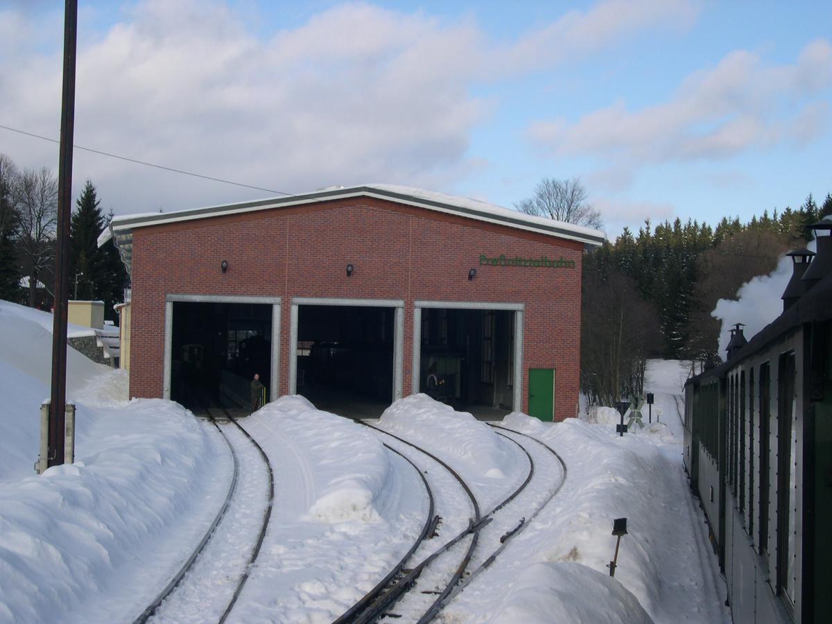 Blick zur Fahrzeughalle mit Schneebergen zwischen den Gleisen.