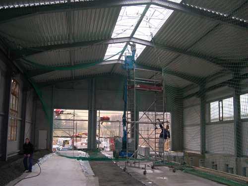 Mit der Fertigstellung der Lichtkuppeln kann das Sicherungsnetz unter dem Trapezblechdach wieder abgebaut werden.
