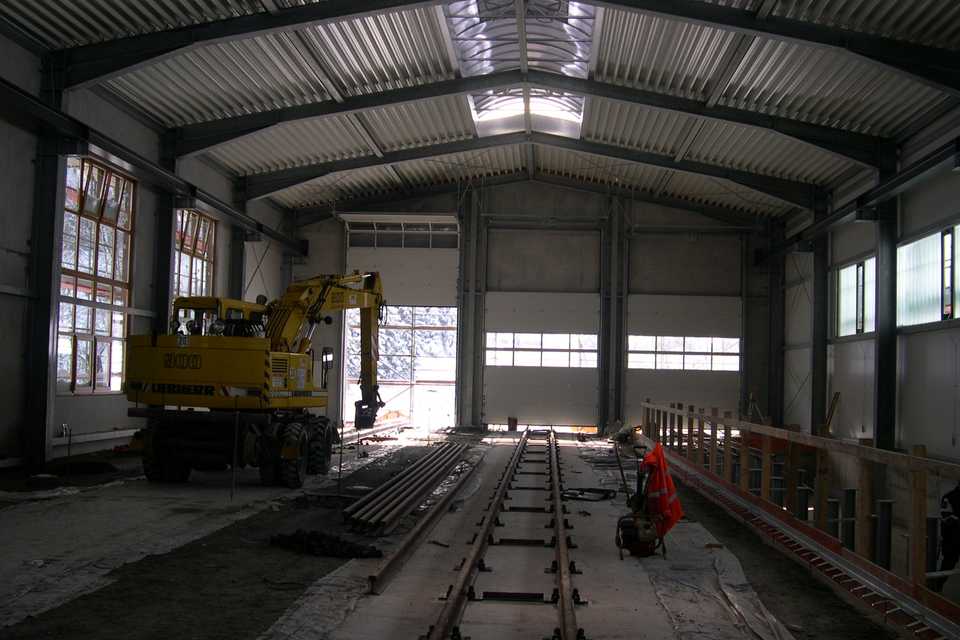 Die Gleisbauer sind in der Halle mit dem Auslegen der Schienen für das Gleis 1 beschäftigt.
