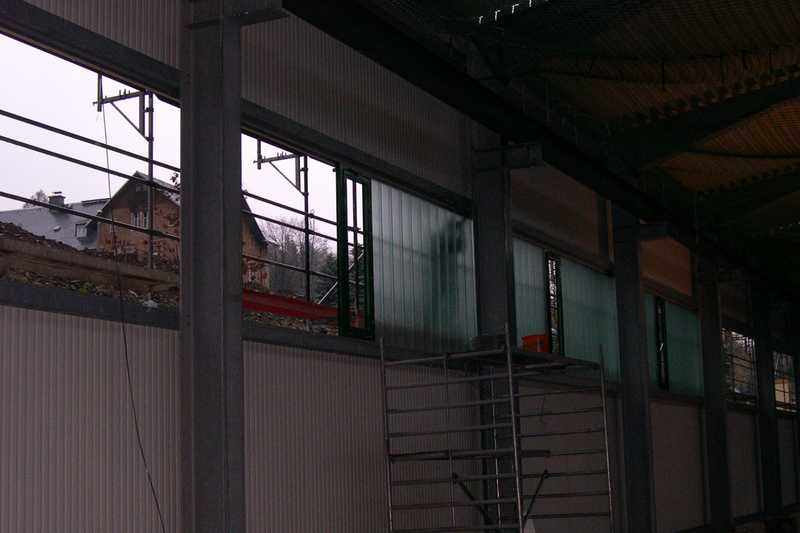 In das Lichtband der hangseitigen Wand werden die Fensterglaselemente eingesetzt. In jedem Feld zwischen den Stützen gibt es ein Fenster mit Öffnungsmechanismus.
