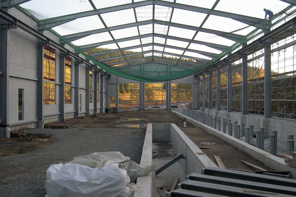Im Dachbereich der Fahrzeughalle werden in Vorbereitung der Dachmontage die Sicherungs- und Fangnetze befestigt.