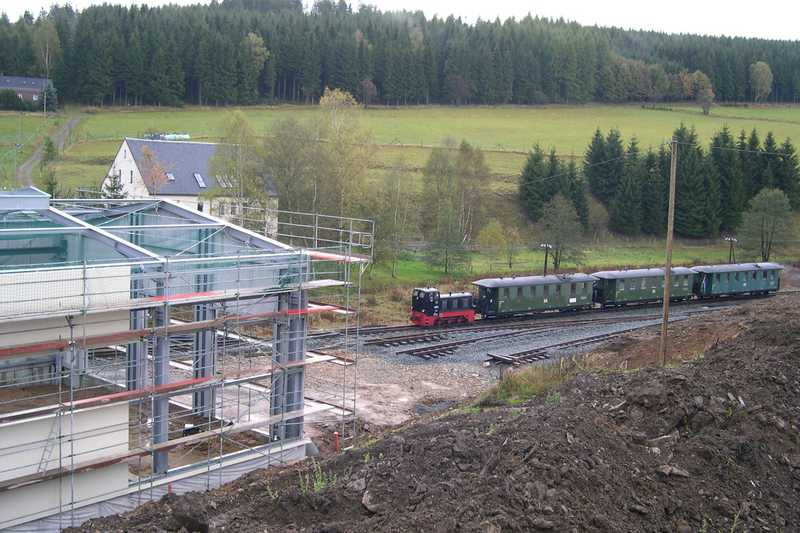 Der Zug der Museumsbahn passiert die Baustelle der Ausstellungs- und Fahrzeughalle.