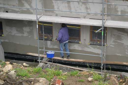 Am Mehrzweckgebäude laufen die Vorbereitungsarbeiten für den Deckputz mit dem Einstreichen der Fensterlaibung und dem Gebäudesockel.