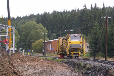 Die Stopfmaschine von Gleisbau Erfurt passiert die Baustelle der Ausstellungs- und Fahrzeughalle.