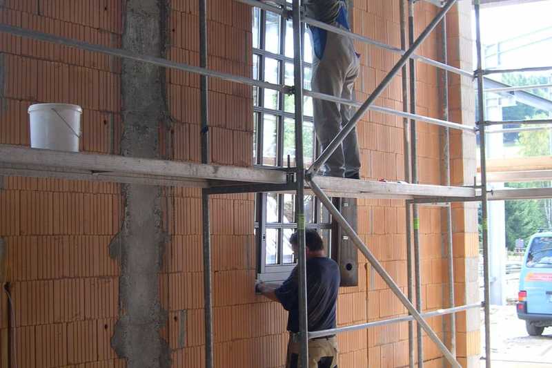 Mit Hilfe des Gerüstes kann in zwei Ebenen am Einbau des Fensters gearbeitet werden.