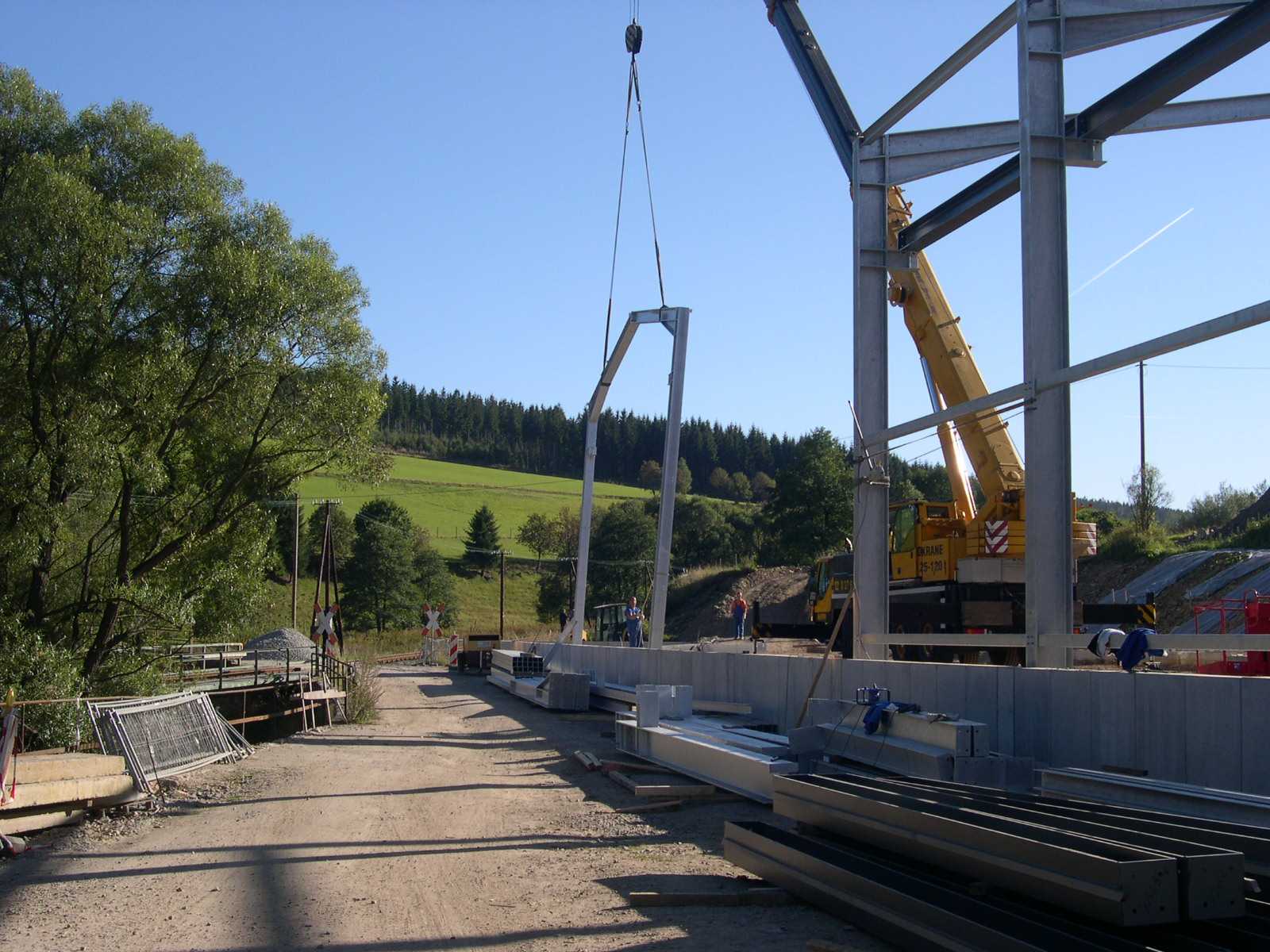 Das nächste Stahlportal wird durch den Mobilkran nach vorheriger Montage aufgerichtet.