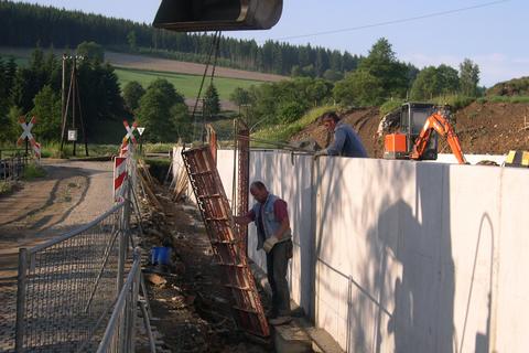 Demontage der Verschalungsplatten für das Betonieren der Lücken zwischen den Winkelstützelementen am Paschweg.