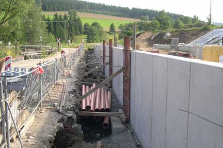 Die Lücken zwischen den Winkelelementen am Paschweg, zwischen denen die Stahlstützen aufgestellt werden, werden verschlossen, danach kann der Einbau der Entwässerung und die Verfüllung des Weges erfolgen.