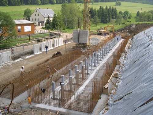 Blick vom Rest der ehemaligen Wasserkraftanlage auf die Baugrube mit den Stützen für das Gleis 3.