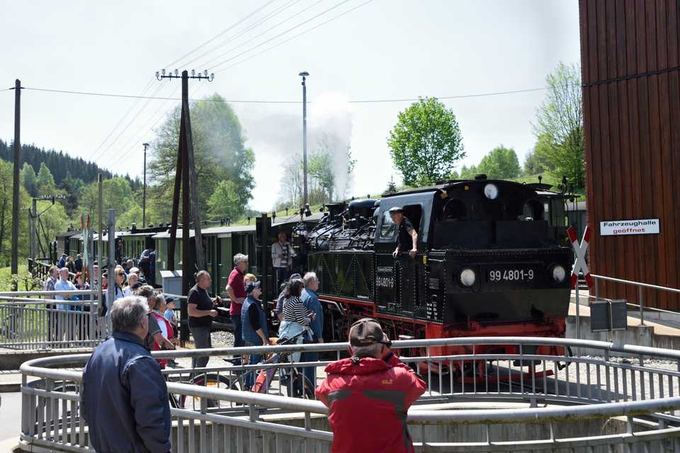 Der „Rügenzug“ mit 99 4801-9 passiert die Ausstellungs- und Fahrzeughalle.