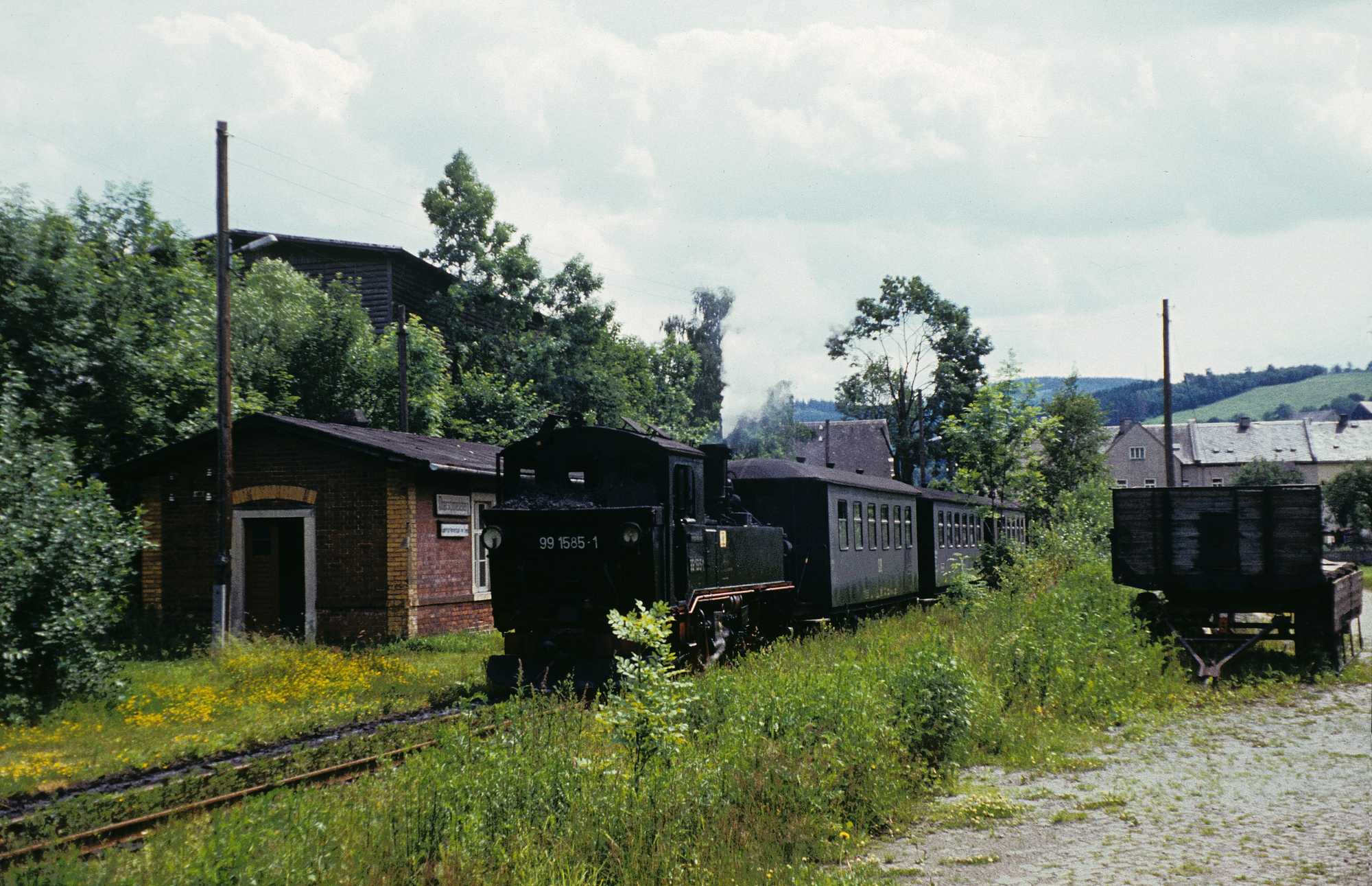 Ein kurzer aus IV K 99 1585-1 und drei Reko-Klassen gebildeter Zug in Fahrtrichtung Wolkenstein am Stationsgebäude Oberschmiedeberg.