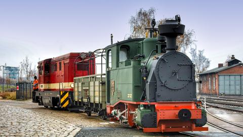 Die L45H der Sächsischen Dampfeisenbahn-Gesellschaft rangiert die I K Nr. 54 und den „Bänkelwagen“ 4333K der Preßnitztalbahn in das Gebäude des Tagungszentrums der Sächsischen Wirtschaft.