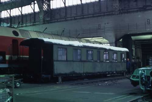 Auf Stützen abgestellt, wartet der Wagenkasten 970-003 nun auf seine grundhafte Aufarbeitung. Daneben eine Lok der Baureihe 229 (DR 219 „U-Boot“).