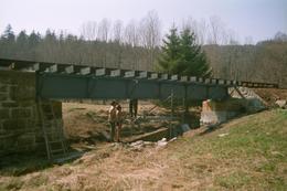 Mittels Gerüst werden die Balken über dem Mühlgraben an der Brücke befestigt.