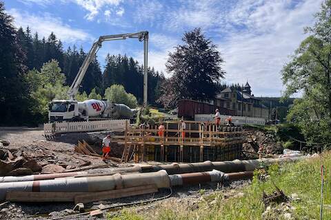 Mit dem großen Ausleger der Betonpumpe wird das Material in die Schalung für das Widerlager auf der Jöhstädter Seite eingefüllt. | 26.07.2024 | Foto: Jana Dost Mit dem großen Ausleger der Betonpumpe wird das Material in die Schalung für das Widerlager auf der Jöhstädter Seite eingefüllt.