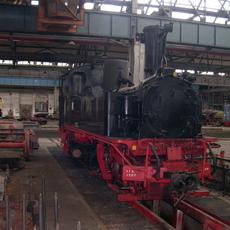 Die Lok steht in der Lokrichthalle des Dampflokwerkes Meiningen auf dem 750-mm-Schmalspurgleisstand.